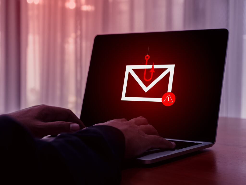 Une tentative de hameçonnage (ou phishing) est illustrée par un hameçon sur un écran d'ordinateur.