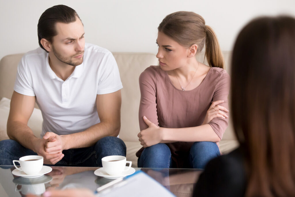 Un couple échange sur le partage des biens sous l'oeil d'un professionnel